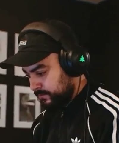 Keiner Valencia at his desk in headphones, editing on a laptop